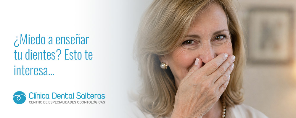 Persona tapándose la boca al sonreír por complejo dental.